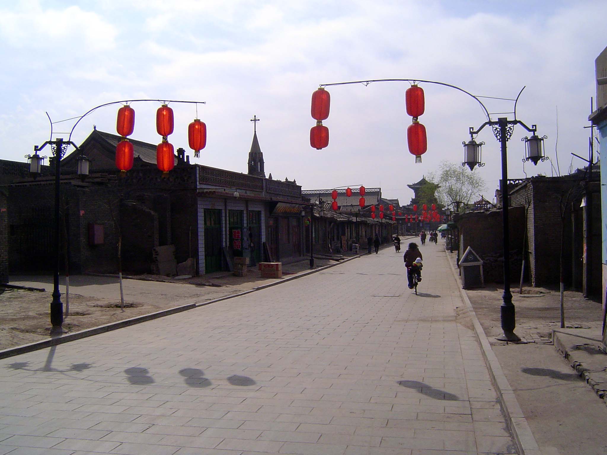 Farther east, commercial development drops off. In the distance, the Ting Yu tower over the east gate. You see the church; we'll circle back
