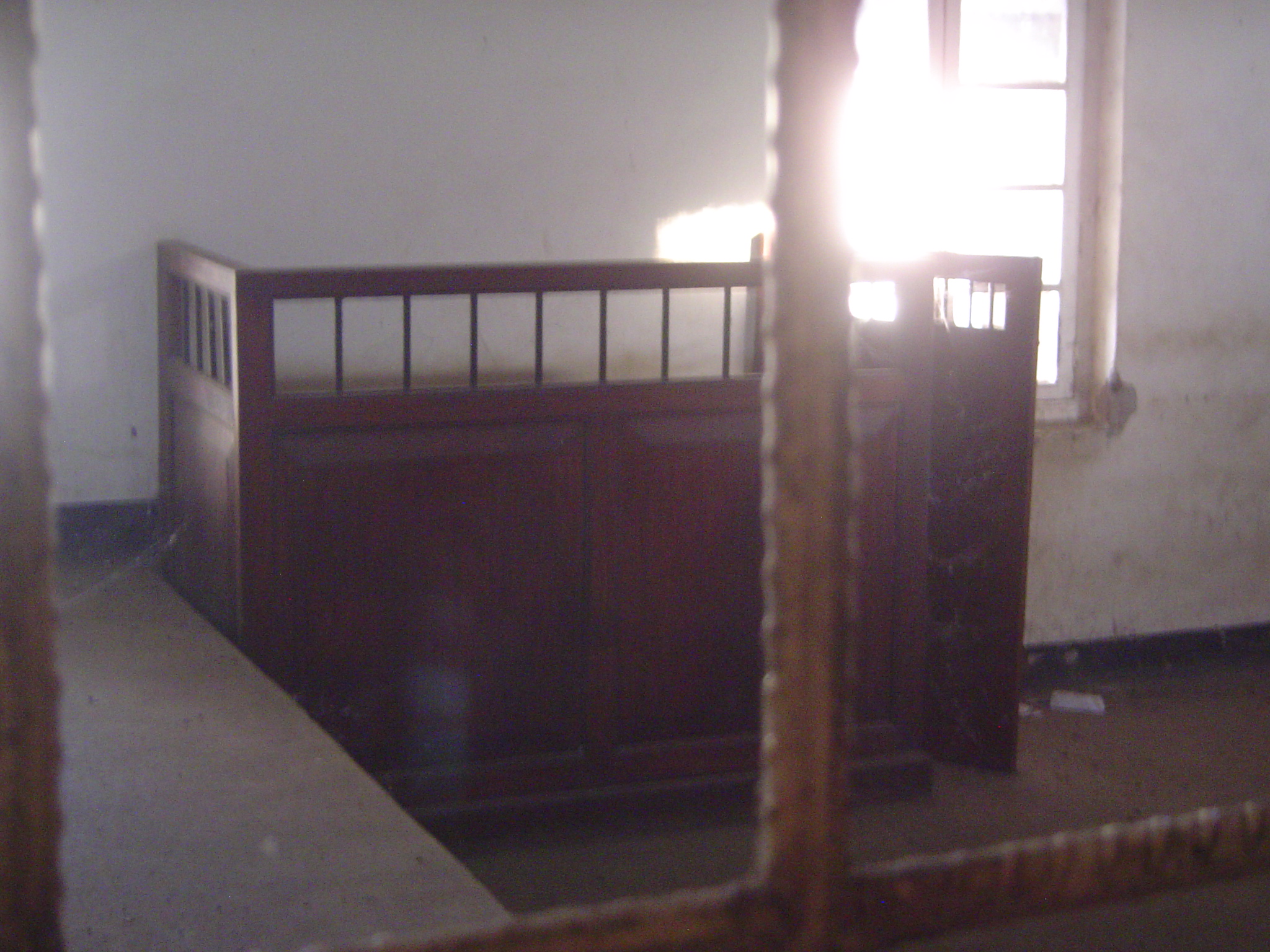 The court-room dock, seen through a dusty window.