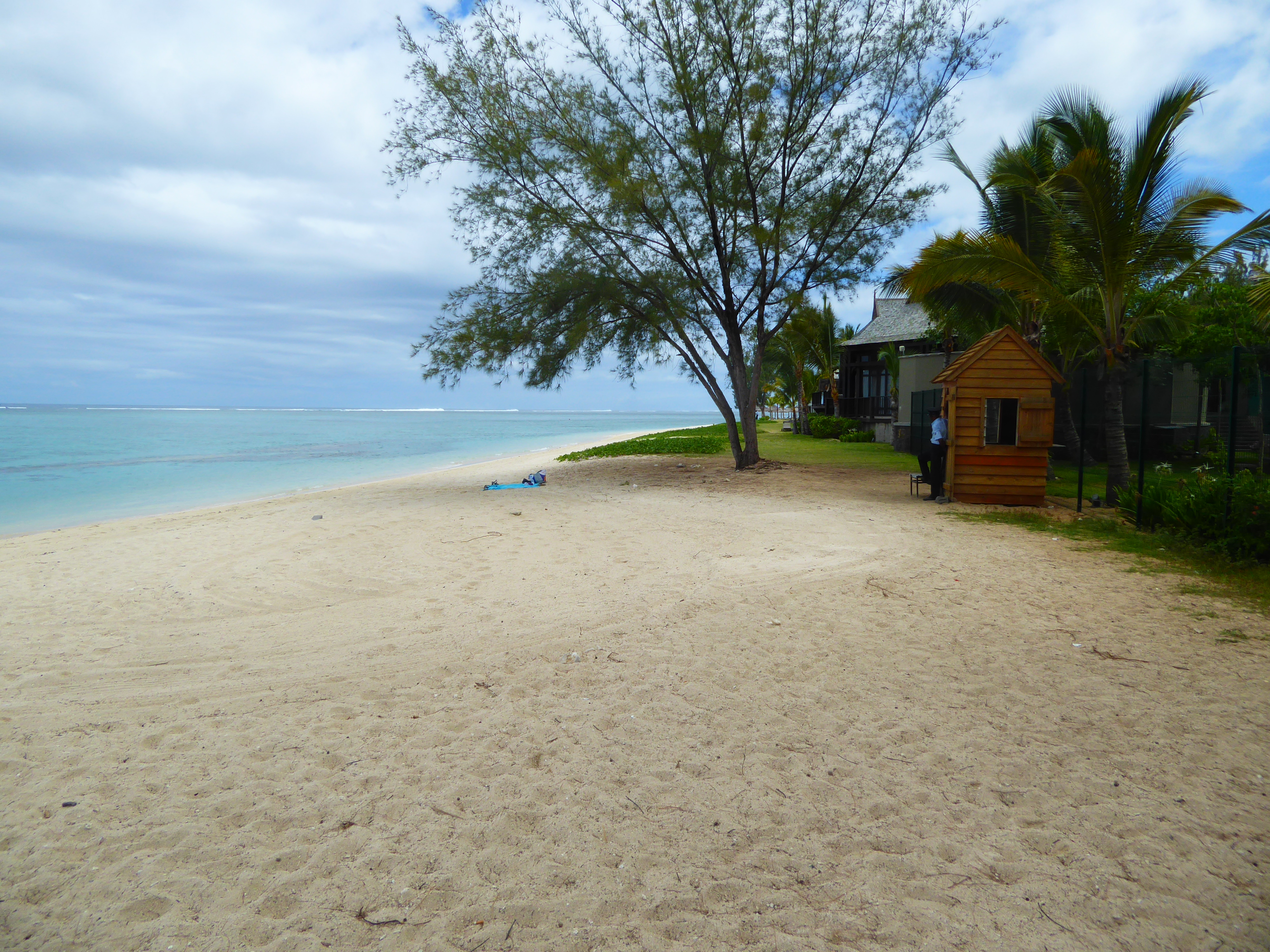 Farther west, a reef once again protects the coast. We're standing on a public beach; beyond the guard, the beach belongs to the first of a