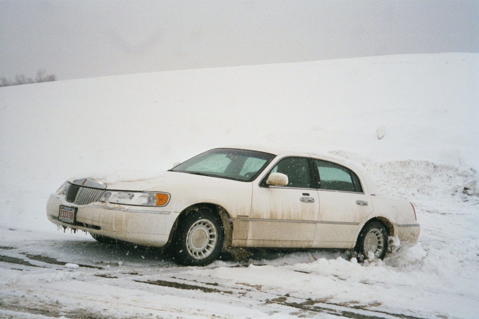 Outsiders do screw up—in this case park on a hill of glare ice, walk away, then watch as their tires lose their grip and the car slides ever
