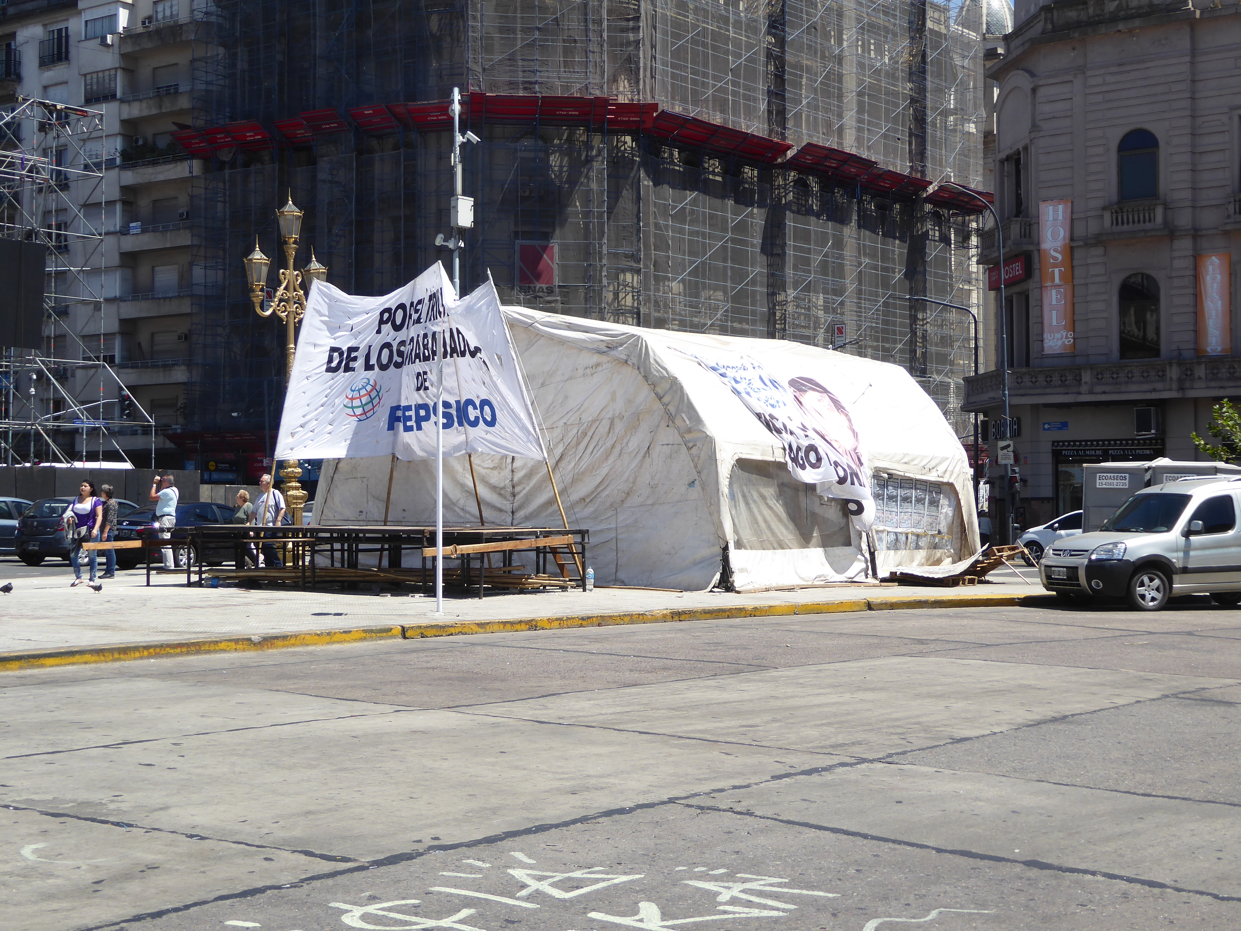 Below the quadriga, a tent is set up by protesters objecting to the closure of an old Pepsico snacks factory in Florida, a crowded Buenos Ai