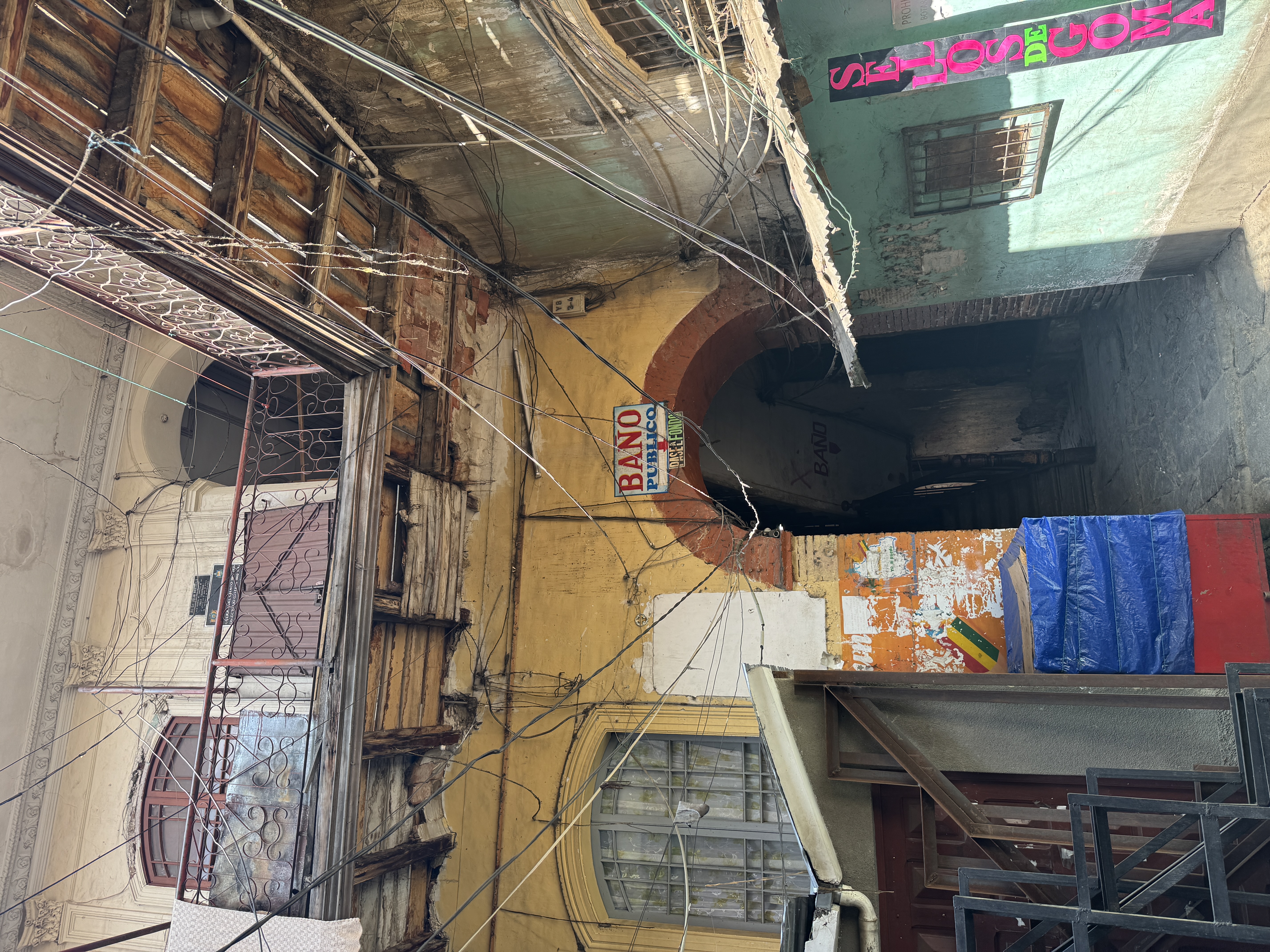 The passage leads to a courtyard with impromptu additions and another passage.