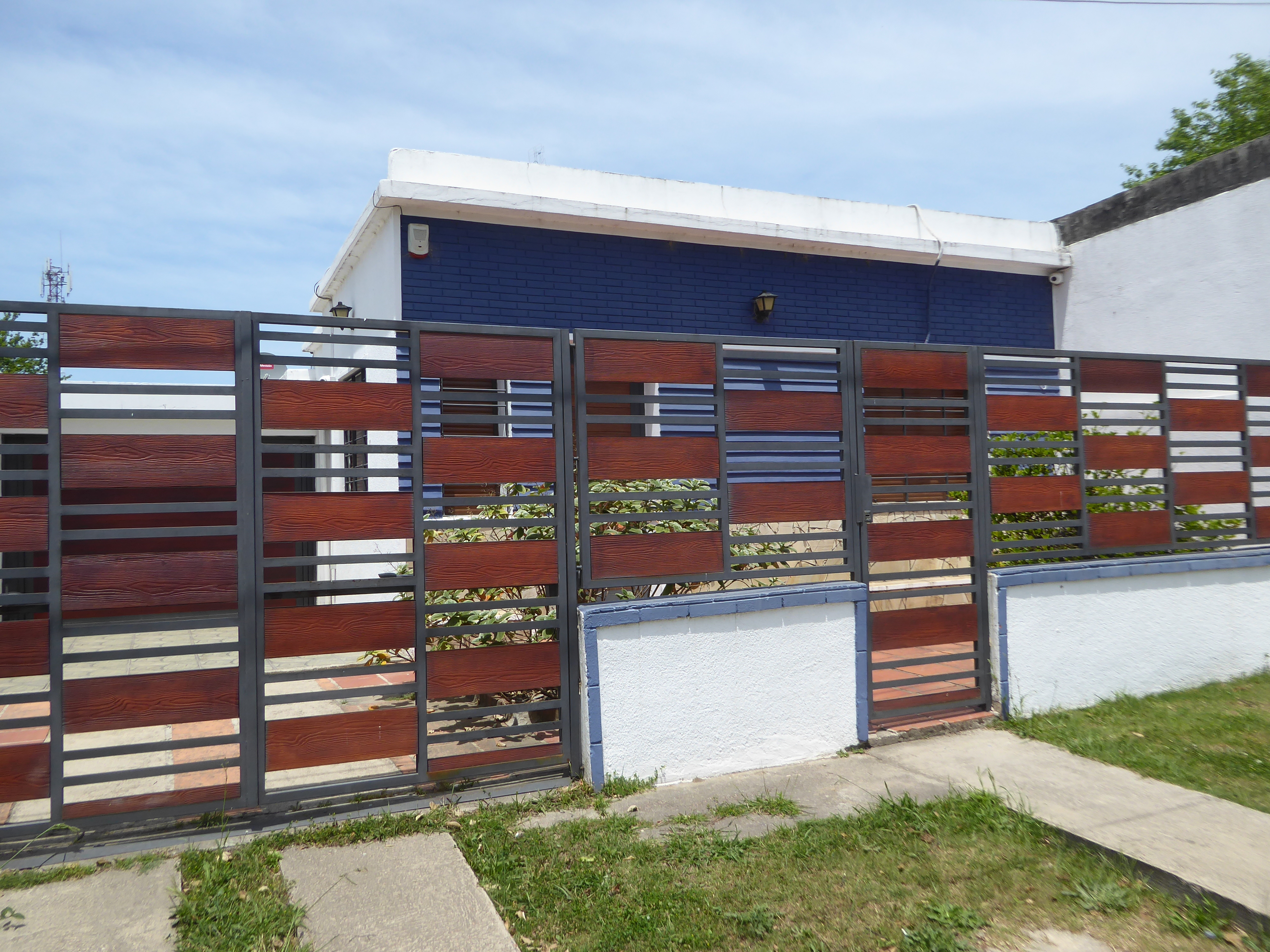 A newesh house with a stylish fence.