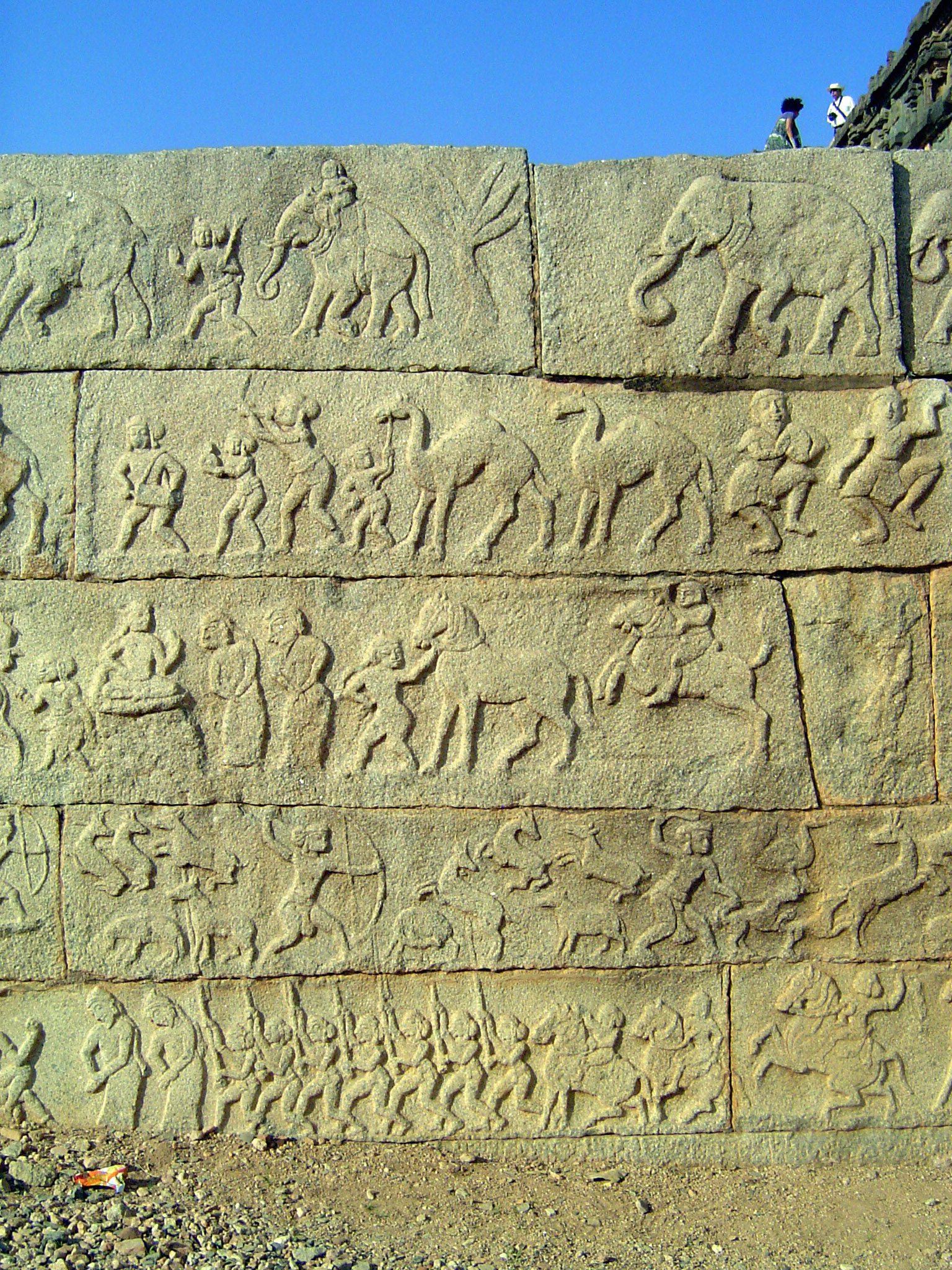 The bottom tier illustrates the king's daily life, with military drills, hunting, obeisances, and exotic entertainments with camels and fore