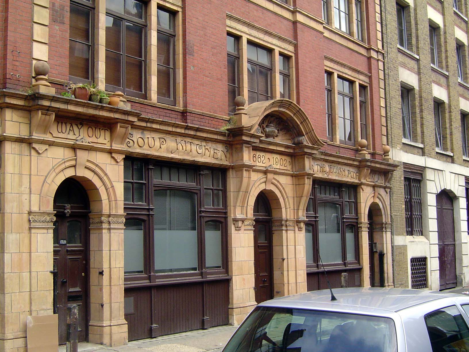 A few blocks to the east, a flash from the past. We're on Whitechapel Road at the Soup Kitchen for the Jewish Poor, dated 1902. Russell and