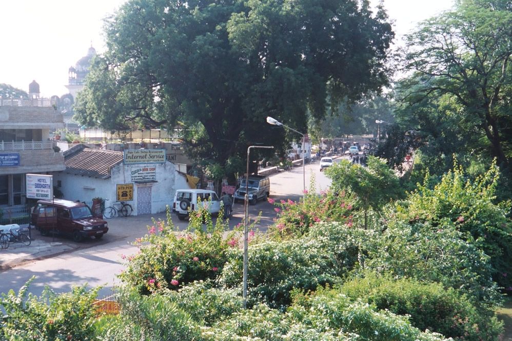 The main temples are in a compound protected by a wall and mass of green. Outside the wall, there are hundreds of people on the lookout for