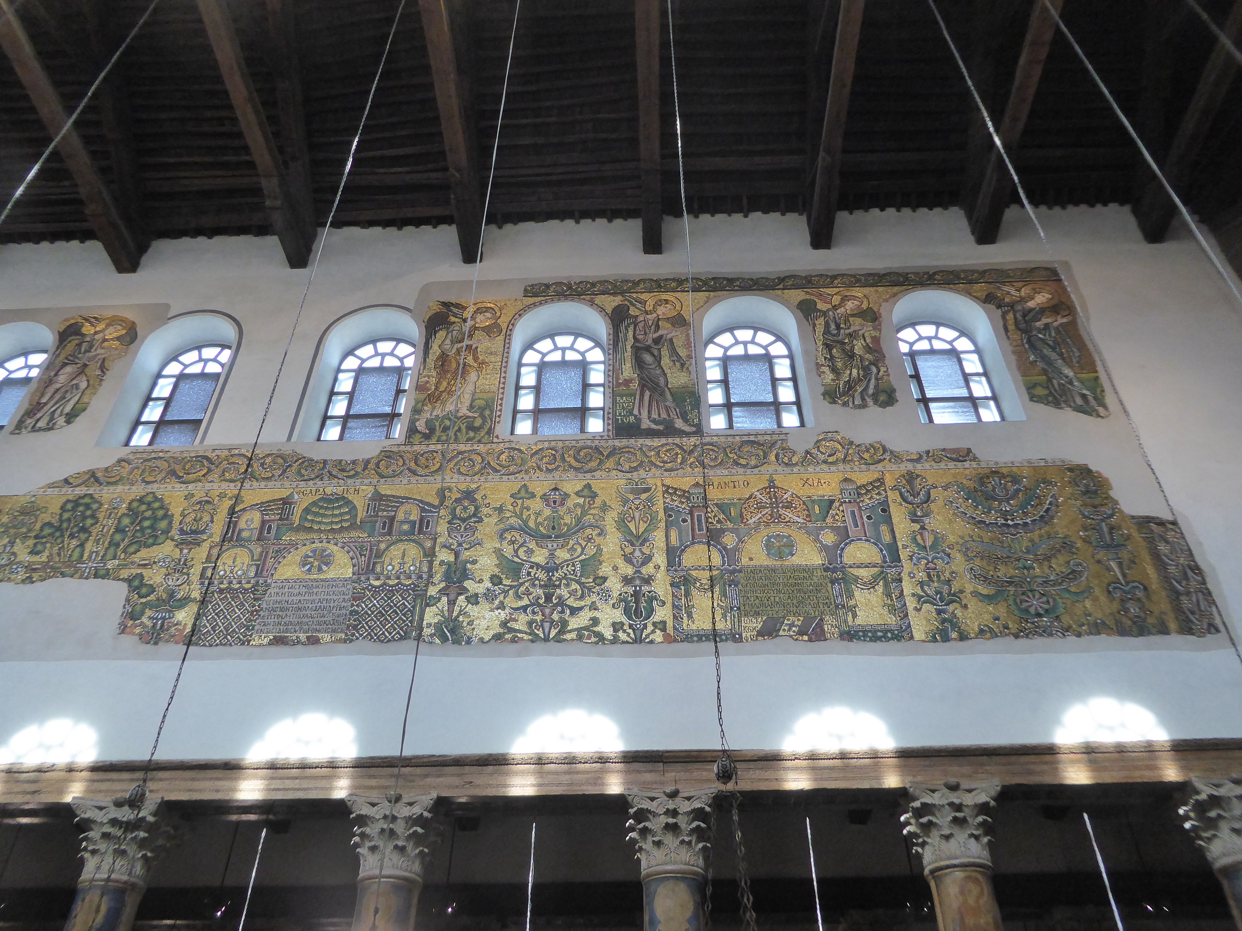 The mosaics date from a restoration in the 12th. Those are angels up top, and the figure third from the right has some letters behind his fe