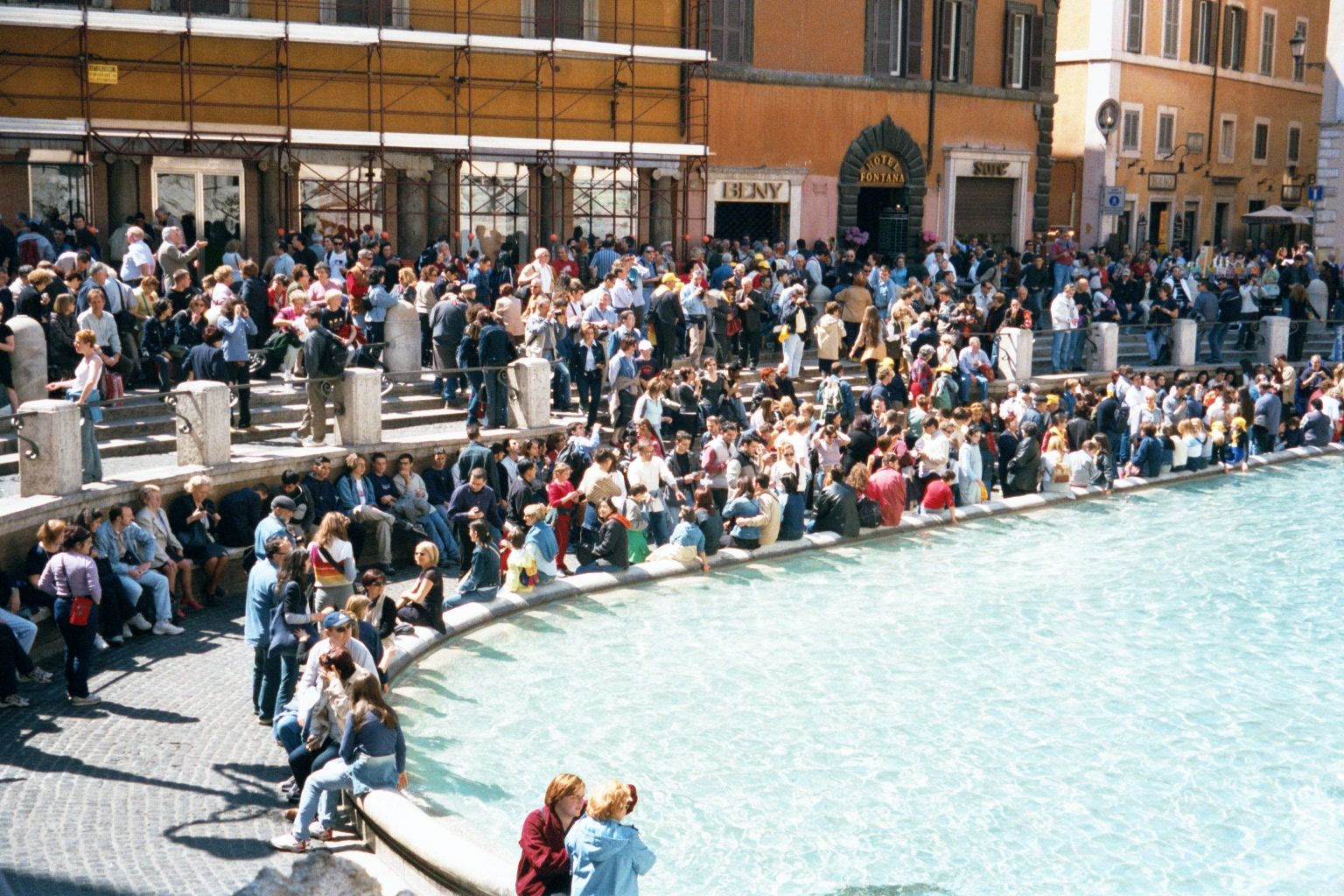 A few blocks away, crowds at the Trevi Fountain wait for something.
