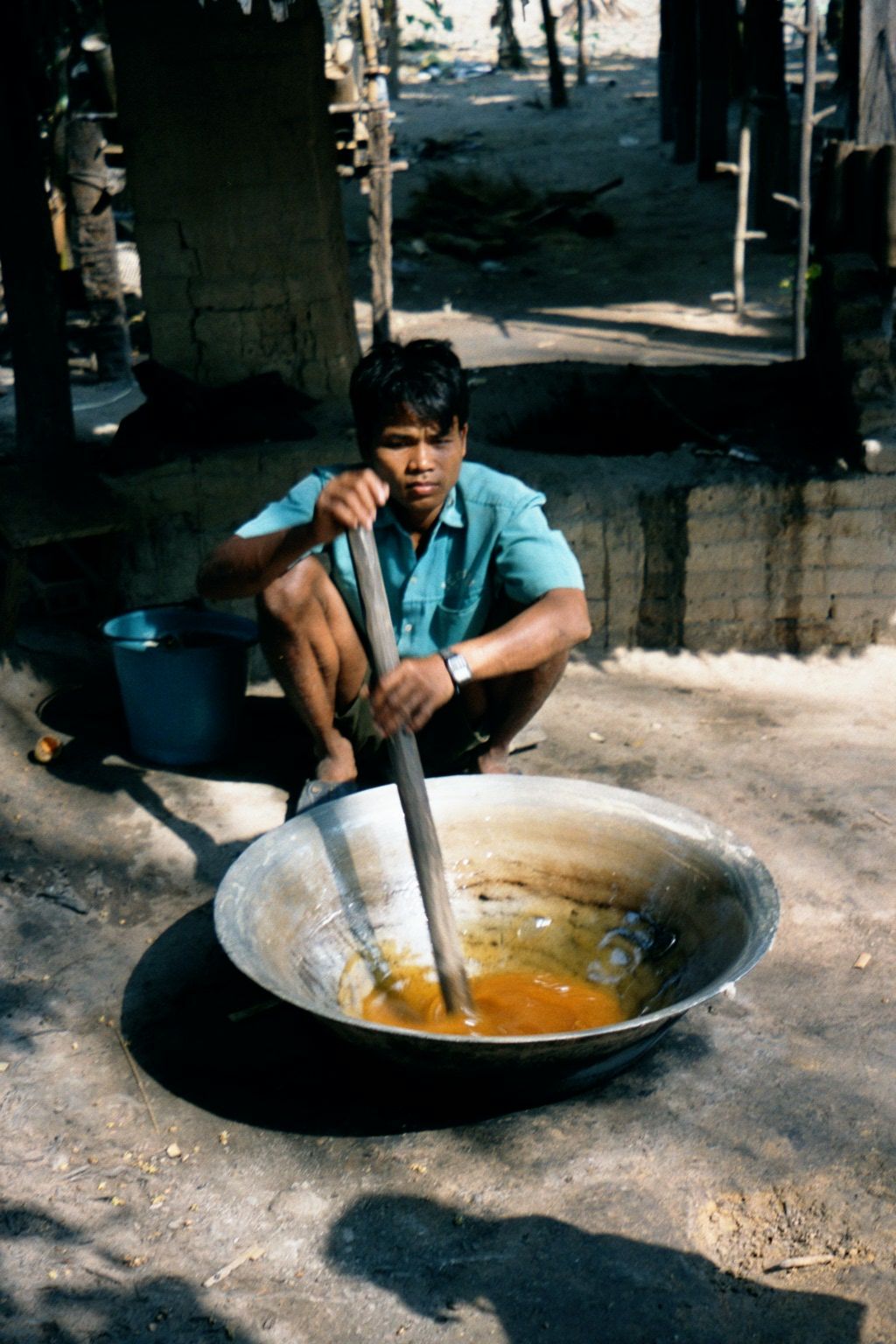 Boiling cane syrup to make chunks of brown sugar wrapped in palm leaves and sold to tourists.