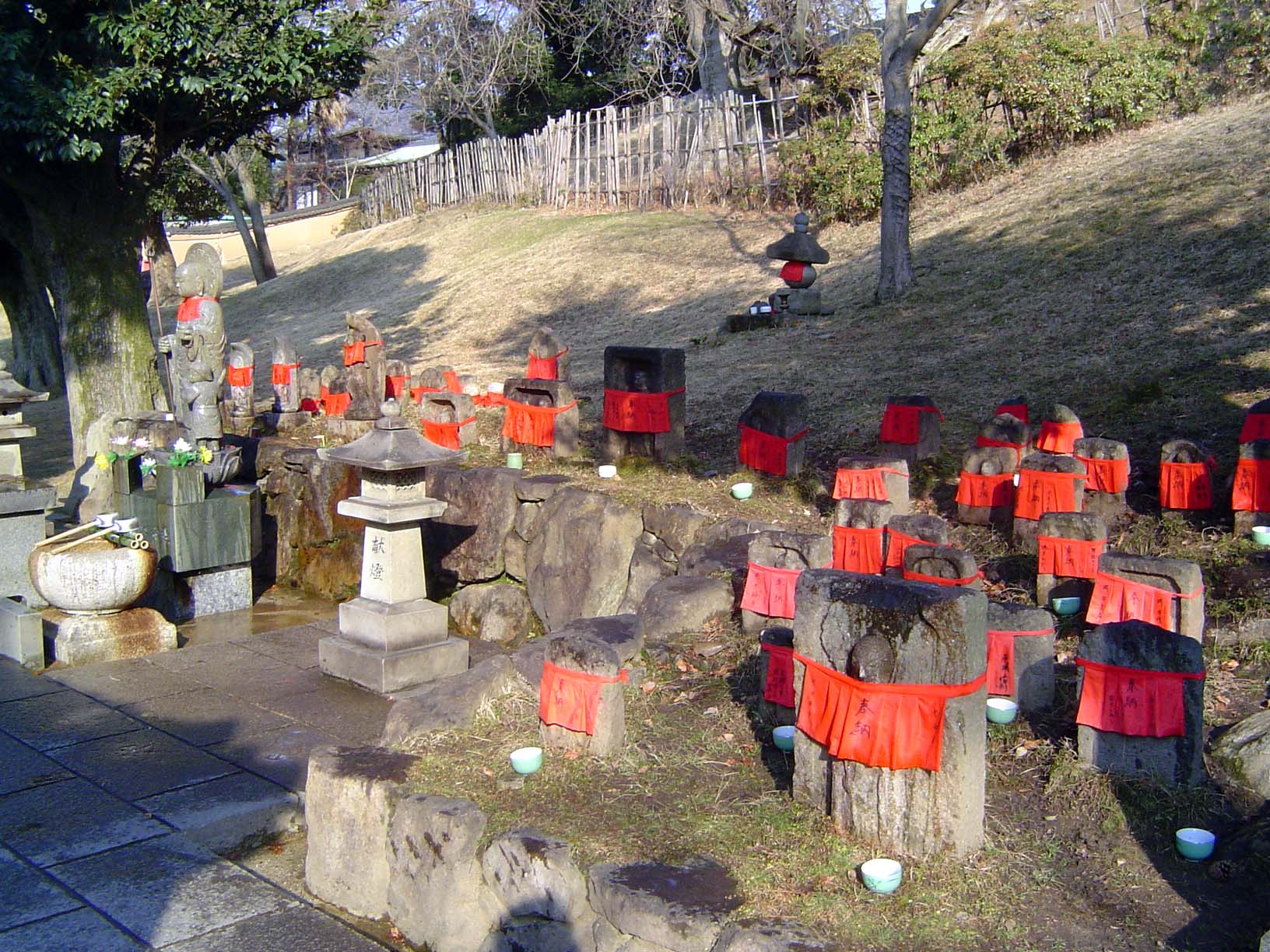 At one corner, stones marking the various guises of the Shinto deity Jizo, who protects women and children, travelers and pilgrims. The red