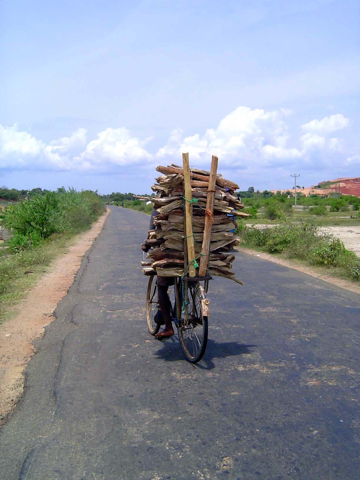 The road in from the north, with fuelwood delivery by bicycle.