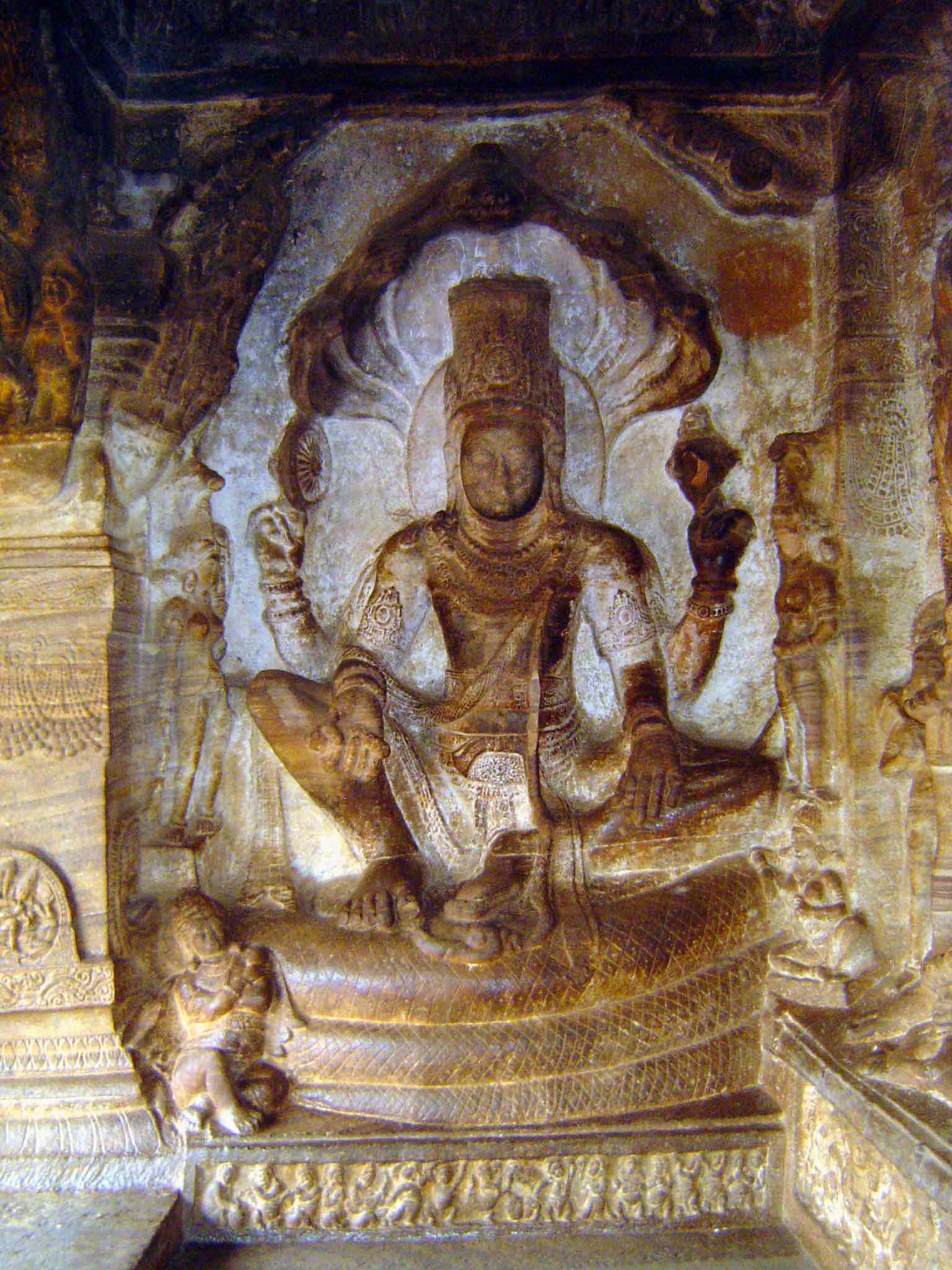Vishnu seated in the maharajalila posture of Buddhist iconography on the great serpent Adisesha, whose five heads flare behind him as an umb