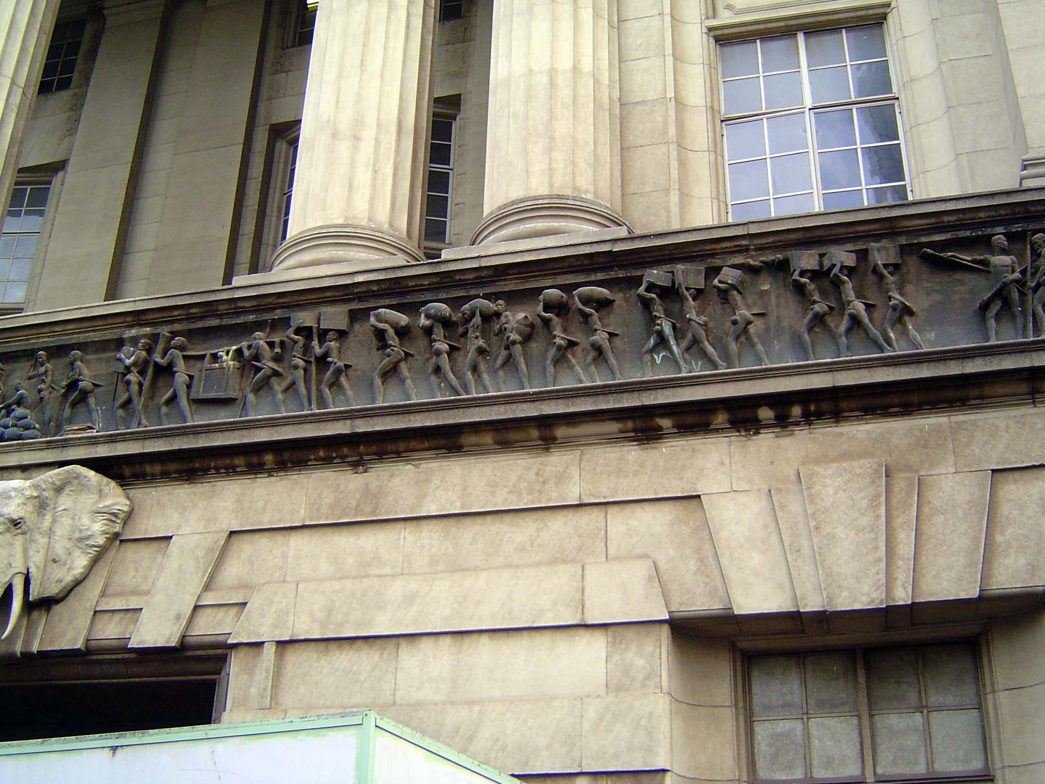 The frieze shows the evolution of land transport, starting with porters.