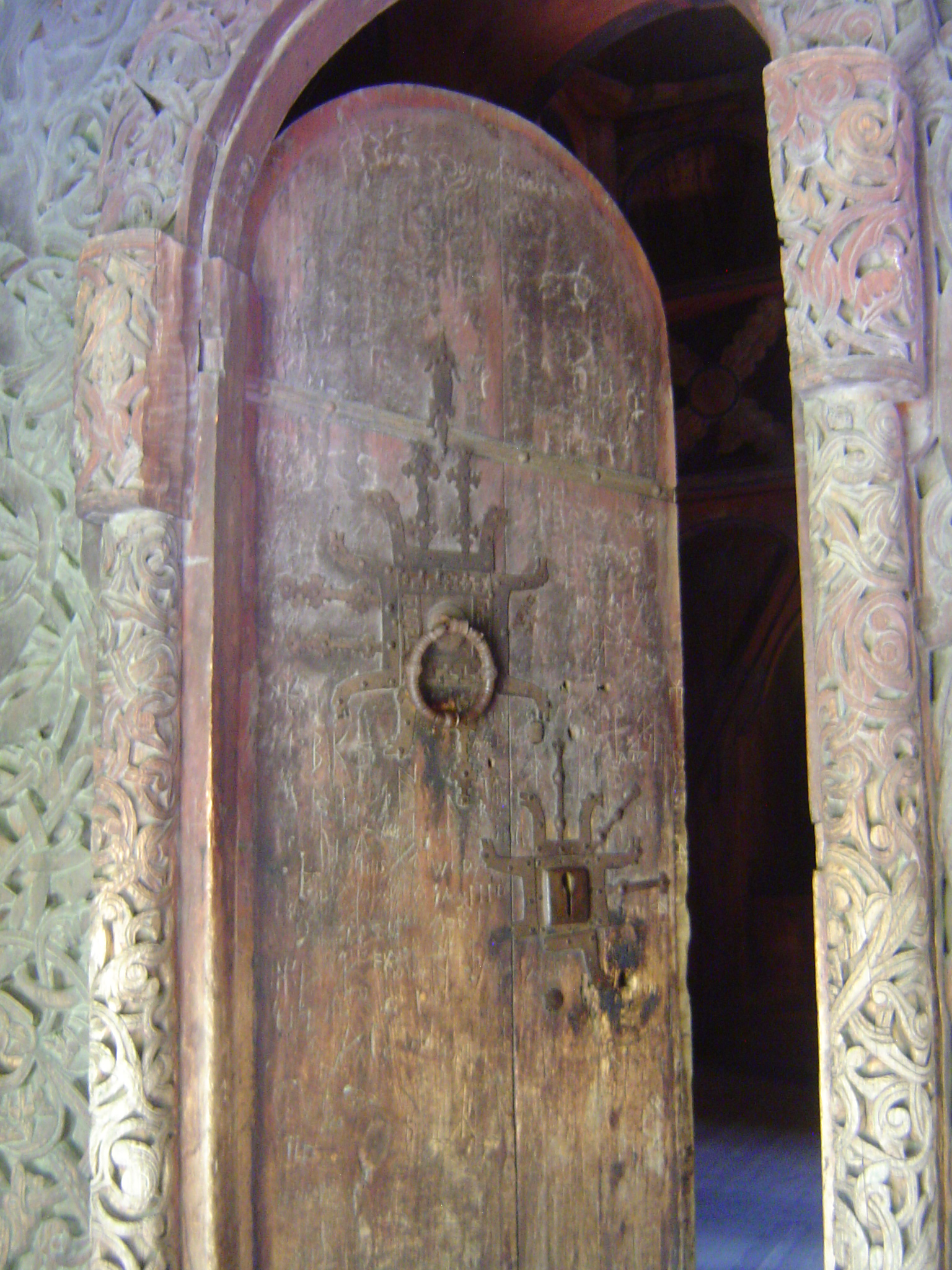 The round-headed door is original, as is the upper strap hinge and the square lock plate. The planks of the door, like all the wood used in