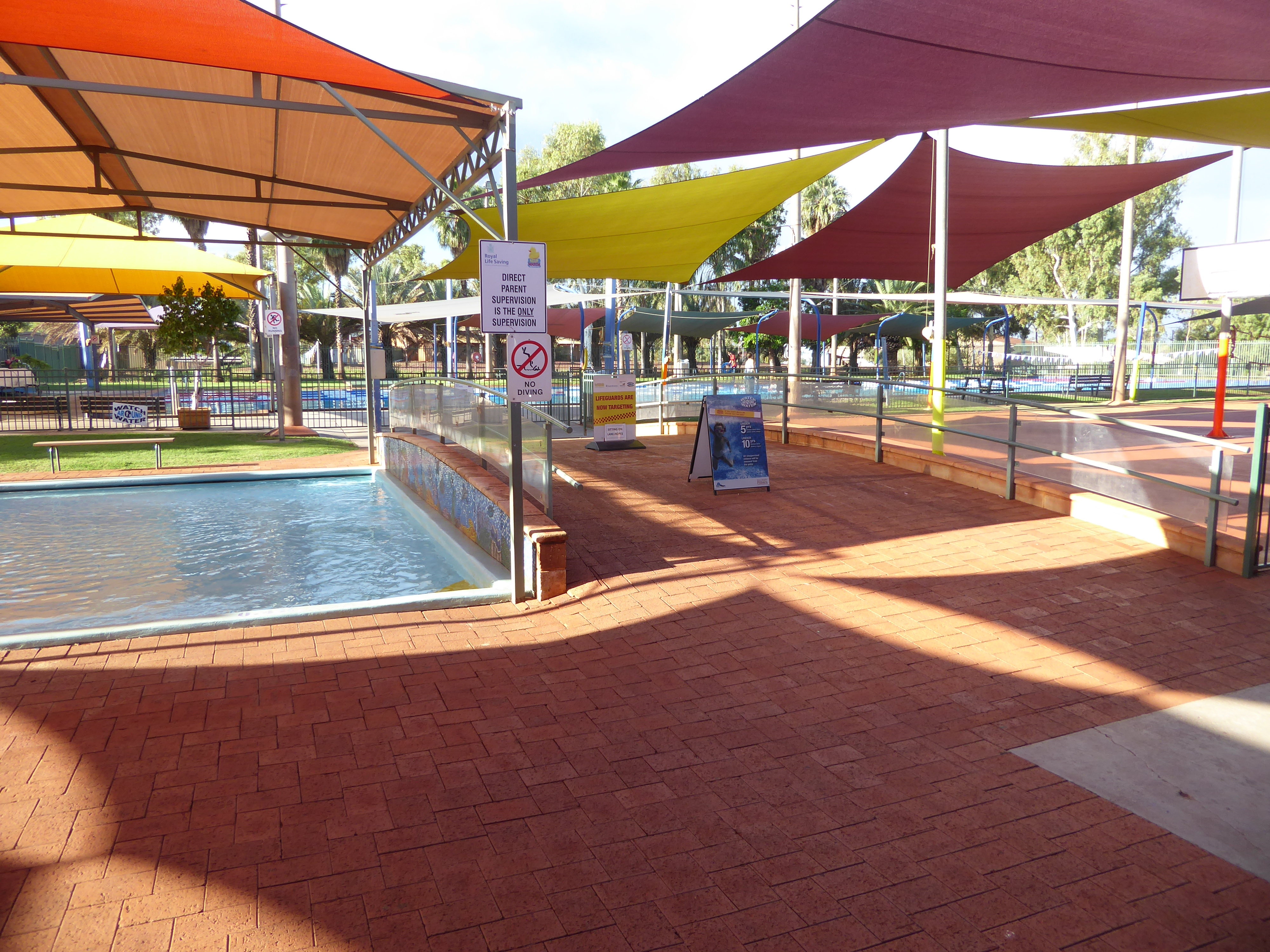 The shade sails on the town's public swimming pool are expensive to buy and expensive to maintain, but trees would have their own downsides—
