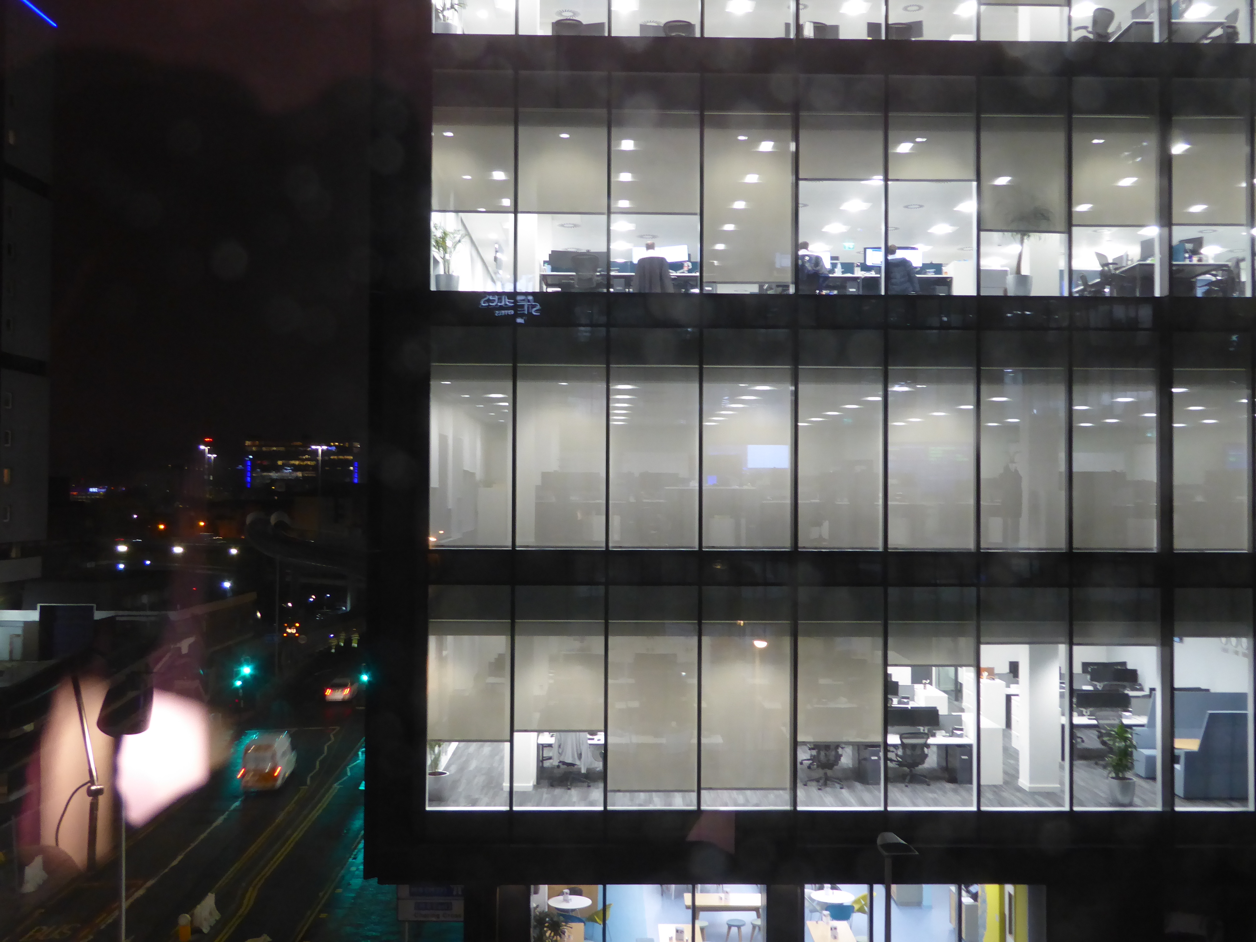 A night-time view of a neighboring investment bank, with a couple of bankers still crunching those numbers.