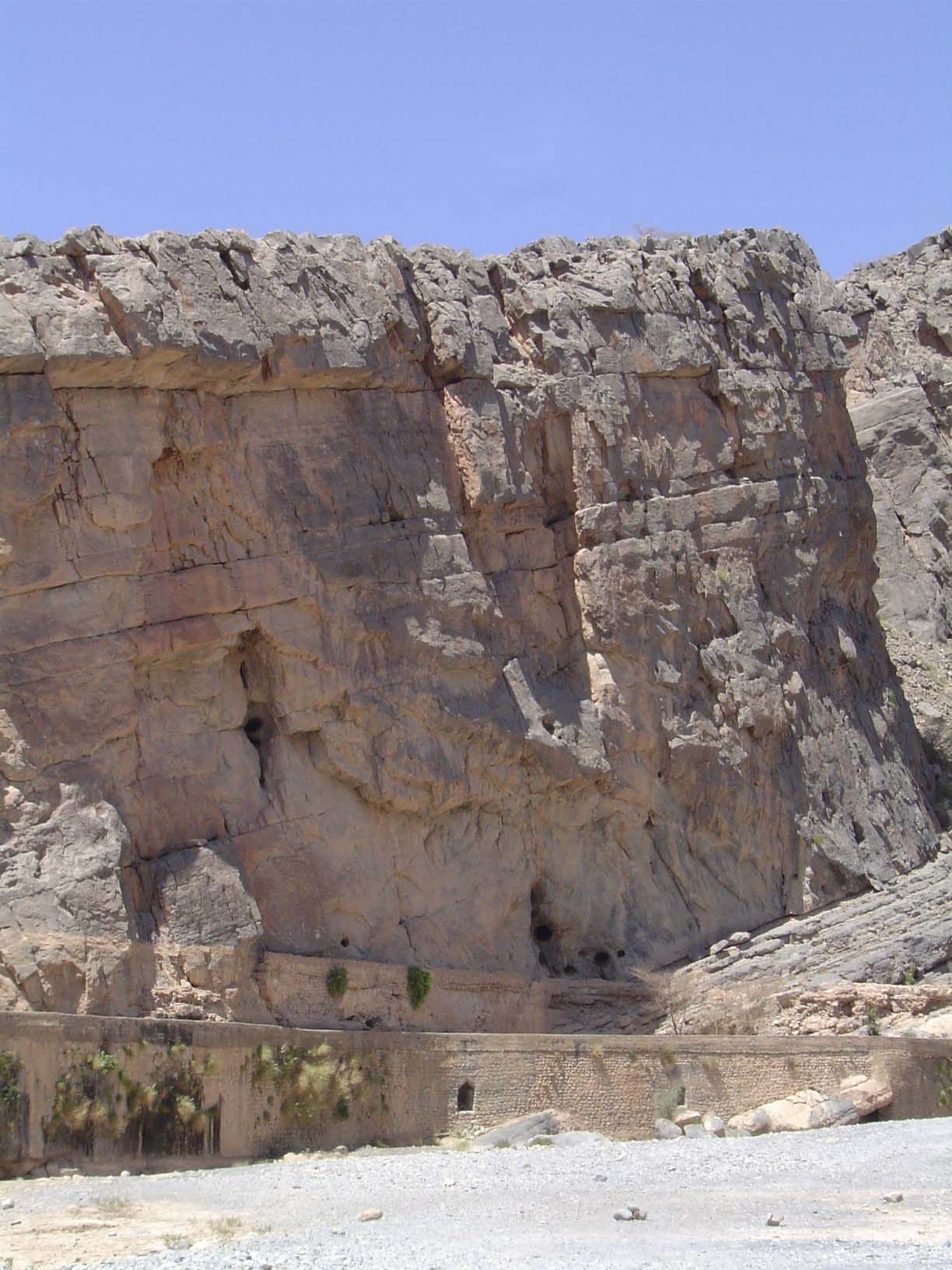 Nearby, a canal said to be 300 years old hugs the canyon wall behind a dry streambed.