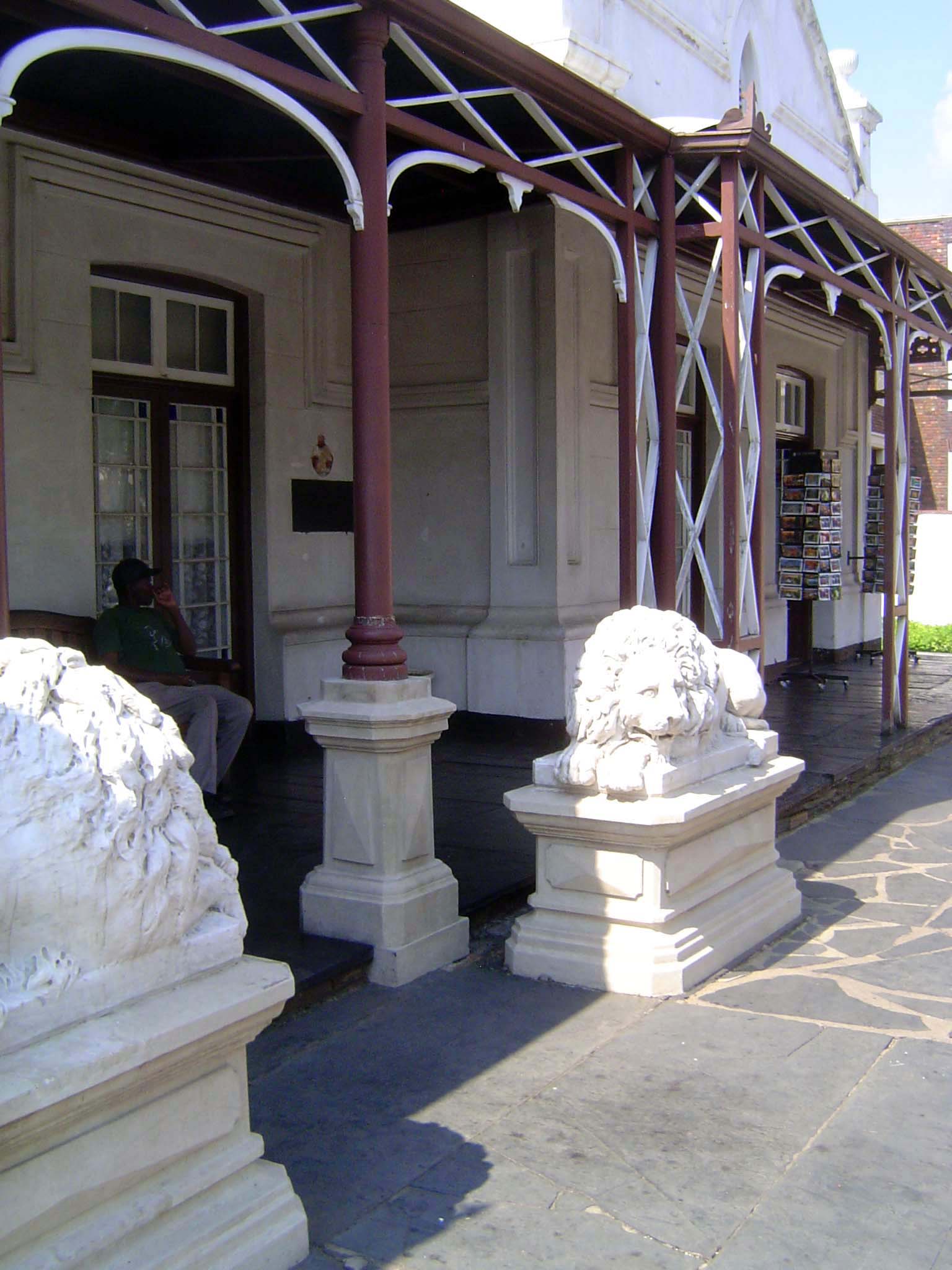 Across the street, the lions outside Kruger's house are too tired to move. Postcard racks mark the entrance to what is now a little-visited