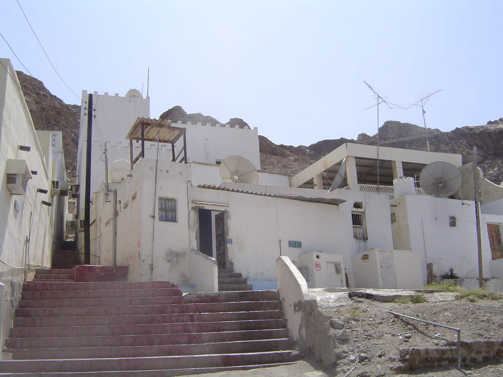 Houses are nothing fancy but are fitted with antennas, dishes, and air conditioners.