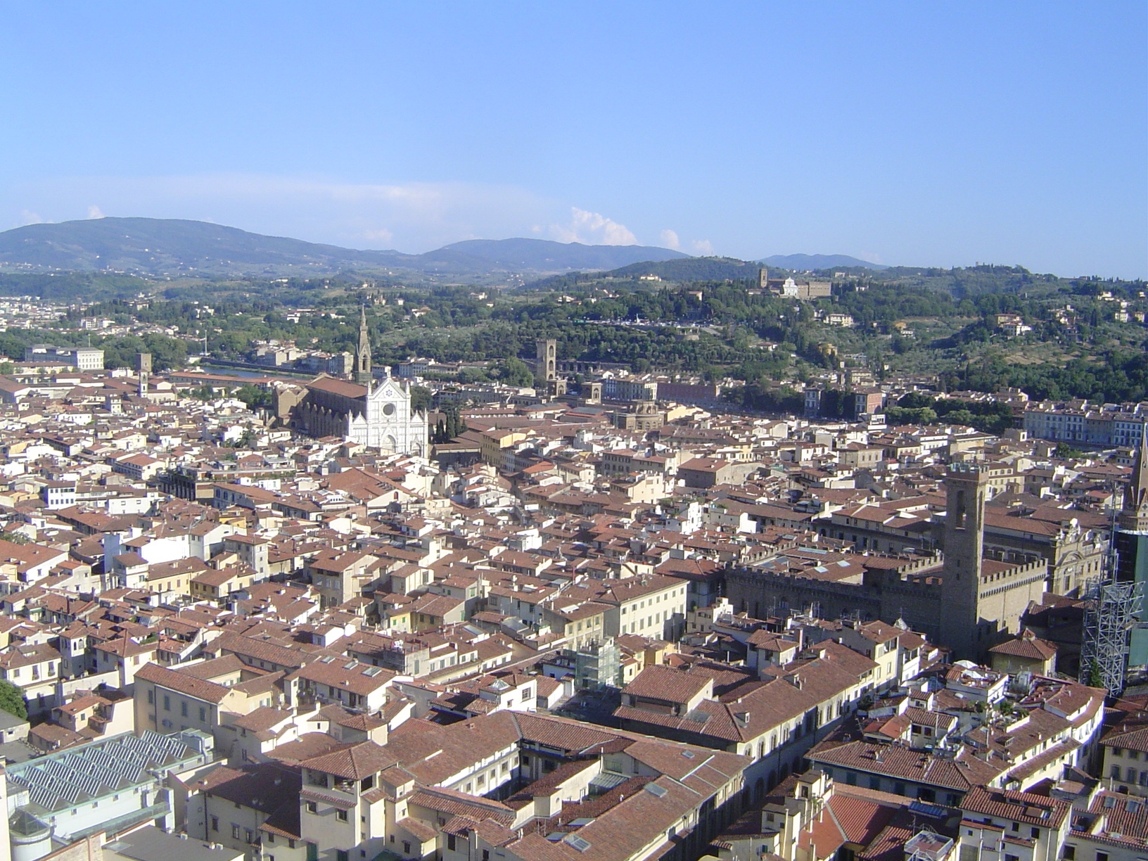 If we swing to the south, the tower of the Bargello comes into view. In the background, atop a hill, is the Church of San Miniato al Monte,