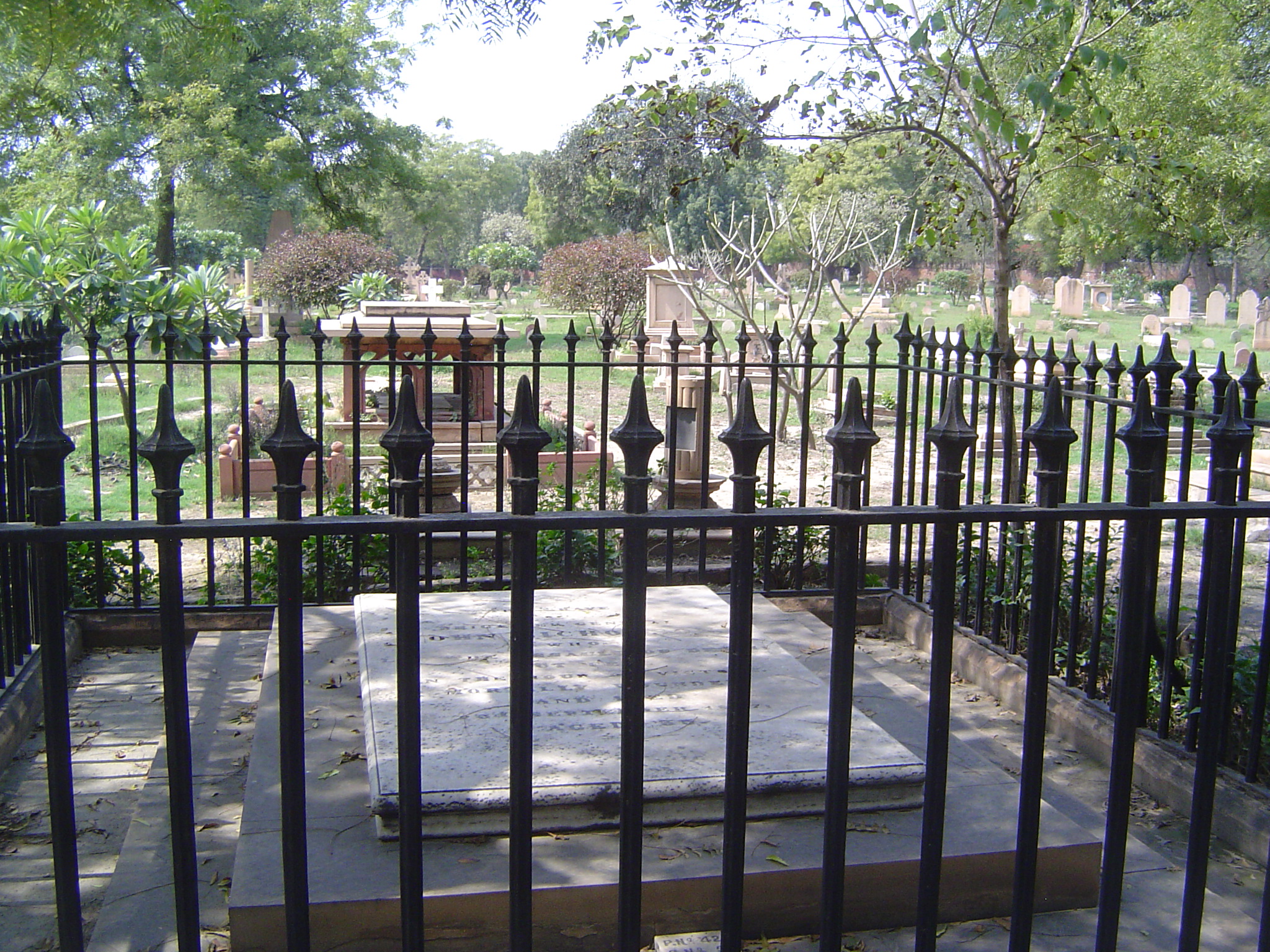 A wider view of the same cemetery, with an iron fence around its most famous occupant.