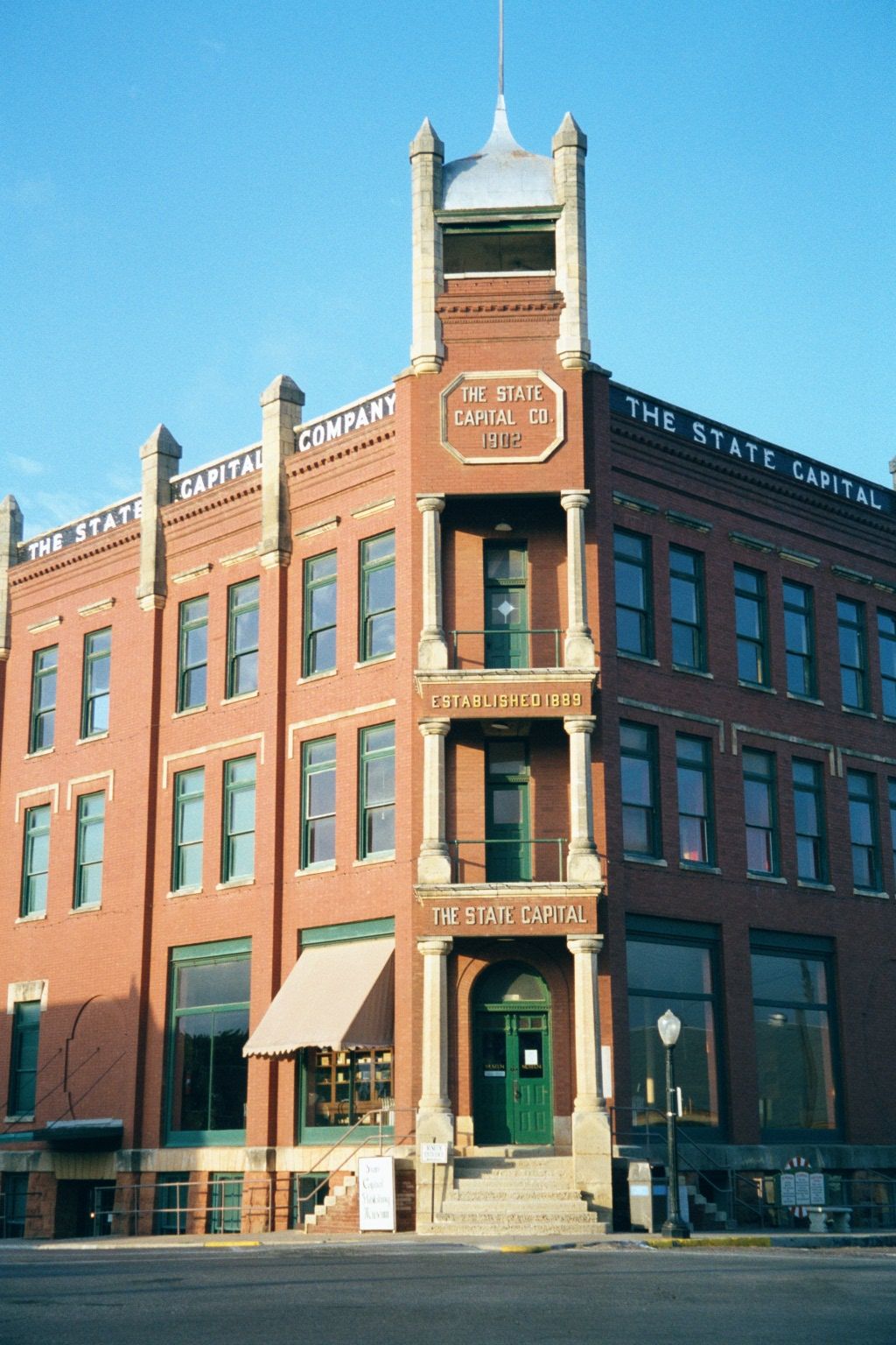 At the edge of town and overlooking the slope to the river, the State Capital Company building housed a bank, newspaper, and printshop; now,