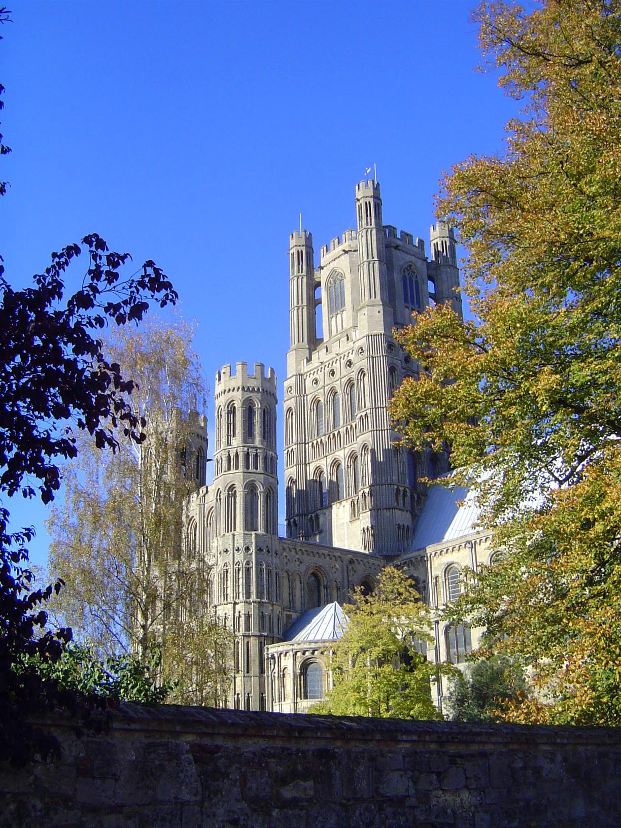The west tower rises above the shorter towers over the entrance porch. The southwest transept flanks the west tower; the northwest transept