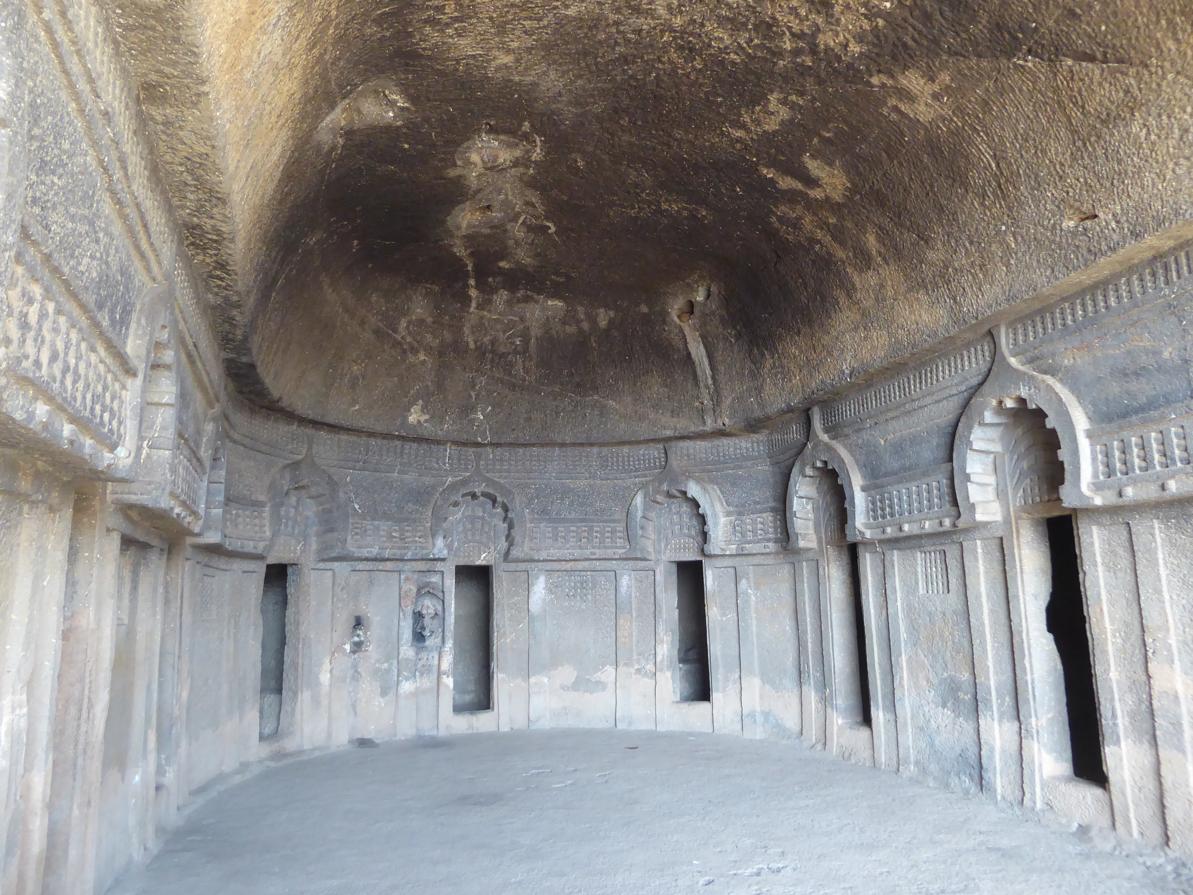 There are 11 cells, each with a bench for sleeping. "Their doors are surmounted by Chaitya-arches connected by a string-course of 'rail-patt