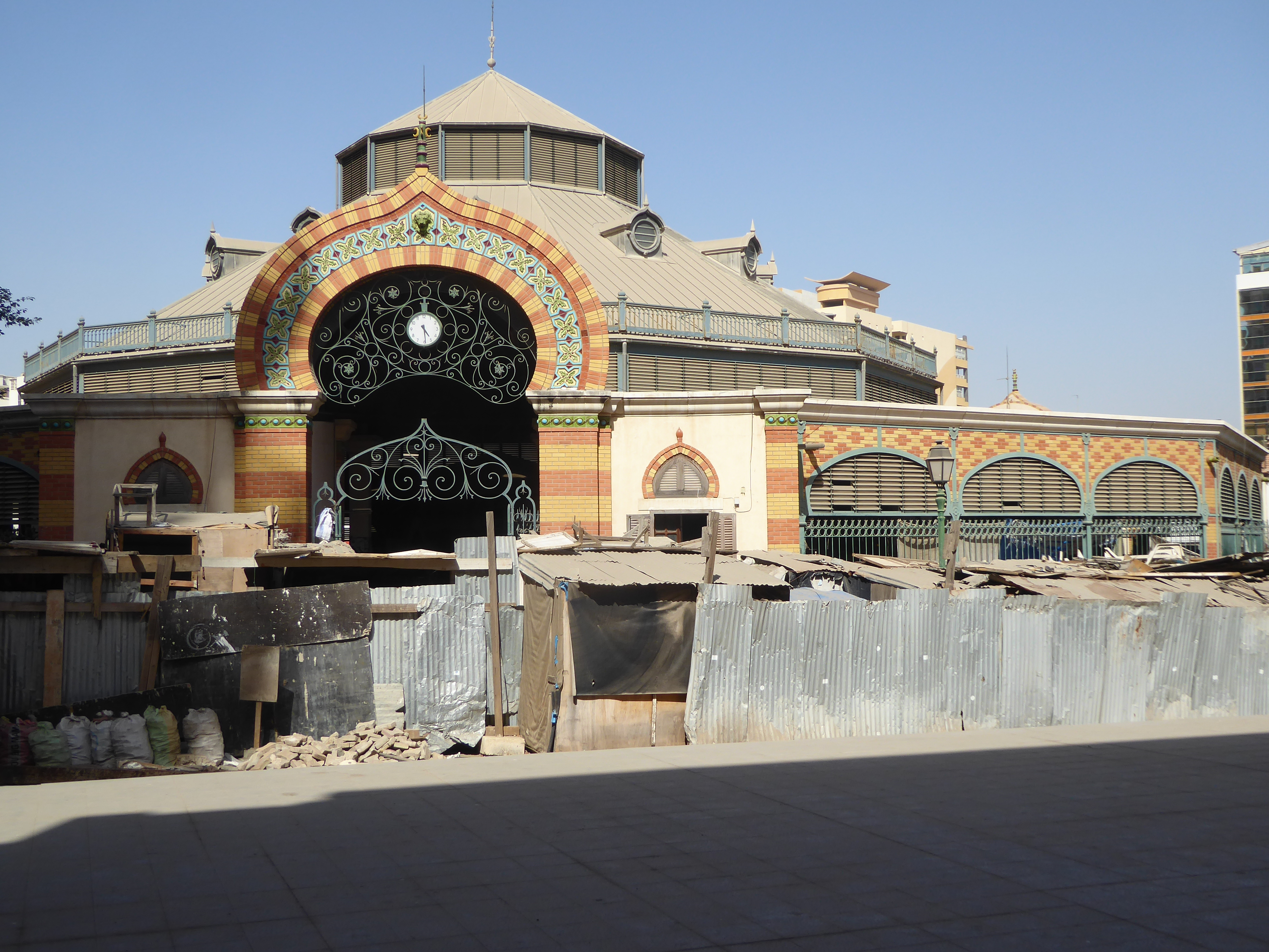The mask-covered wall is part of the Kermel Market, the original European public market. This is a copy, built in 1997 after the original bu