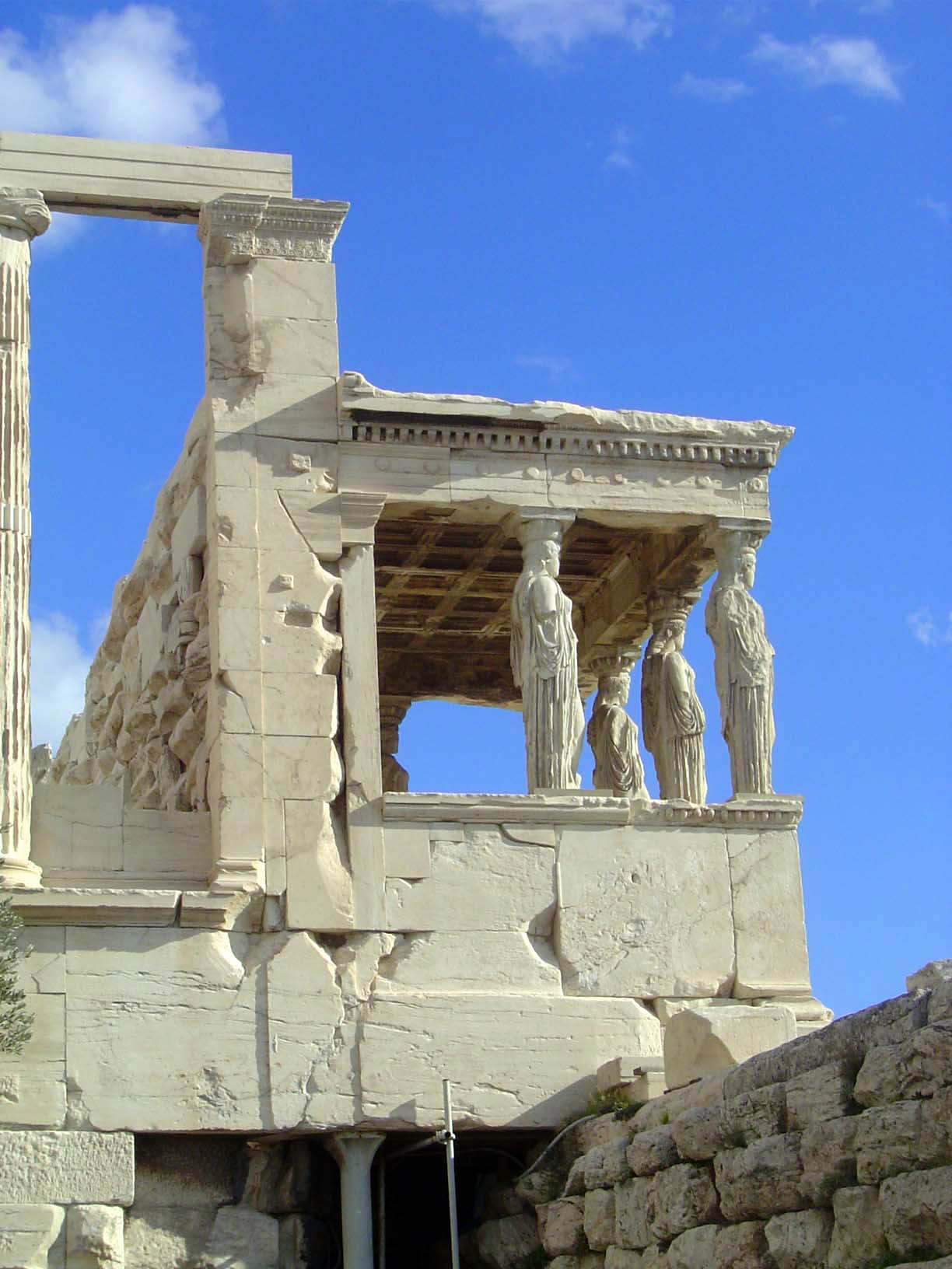 Modern props. The stones on the wall at the lower right are the foundation of the Temple of Athena Polias, destroyed by the Persians in 480